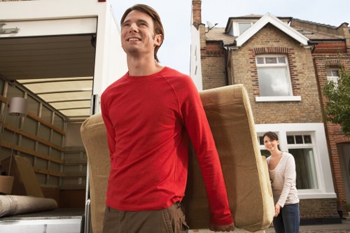 Movers carrying wrapped household items from a Mayfair flat